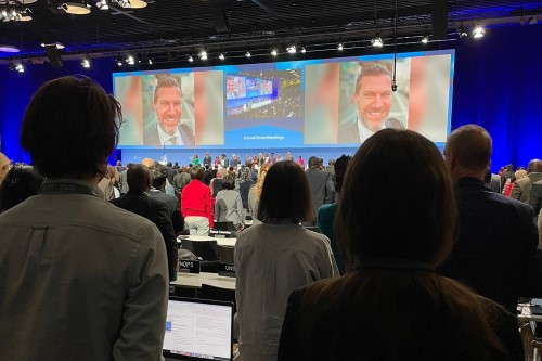 People standing to welcome a speaker at the Bonn Climate Change Conference